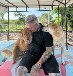 Michael J. Baines cuddles two of the 1,000 dogs in his care at the Sanctuary