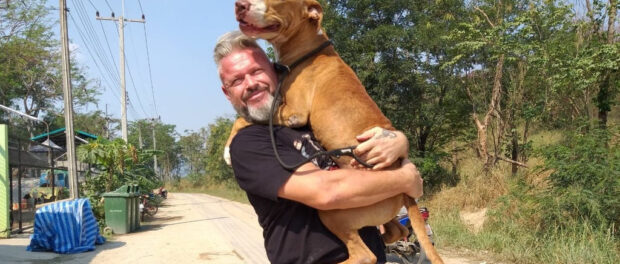 Michael J. Baines poses for a photo as he hugs Blueberry - one of the 1,000 dogs in his care