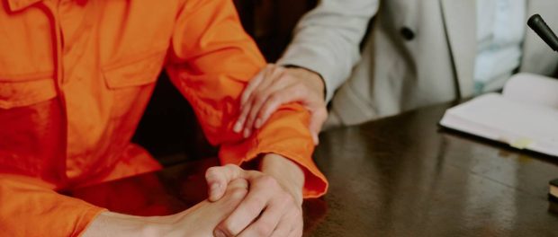 Lawyer providing confidential support to a young man in a courtroom, representing domestic violence bail bond assistance in San Diego.