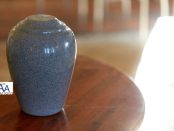 Handcrafted urn, memorial jewelry, and framed photo arranged together as personalized cremation keepsakes.